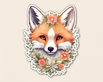 May include: A die-cut sticker featuring the head of a fox with orange and white fur, pointed ears with dark tips, and dark eyes. The fox is framed by a decorative arrangement of light green leaves, small sprigs, and several small coral-colored flowers.