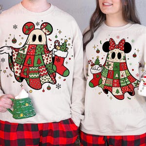 Peut inclure: Ensemble de pyjamas de Noël assortis avec un motif de fantôme avec des oreilles de Mickey Mouse et un motif patchwork rouge, vert et blanc. Le pyjama comprend un haut à manches longues et un pantalon à carreaux rouges et noirs. Le fantôme tient une chaussette et une canne en bonbon.