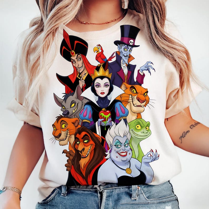 Puede incluir: Una camiseta color crema con un gr&aacute;fico colorido de varios villanos de Disney. El gr&aacute;fico incluye personajes como Jafar, la Reina Malvada, Scar y &Uacute;rsula. El dise&ntilde;o es una ilustraci&oacute;n vibrante de personajes animados.