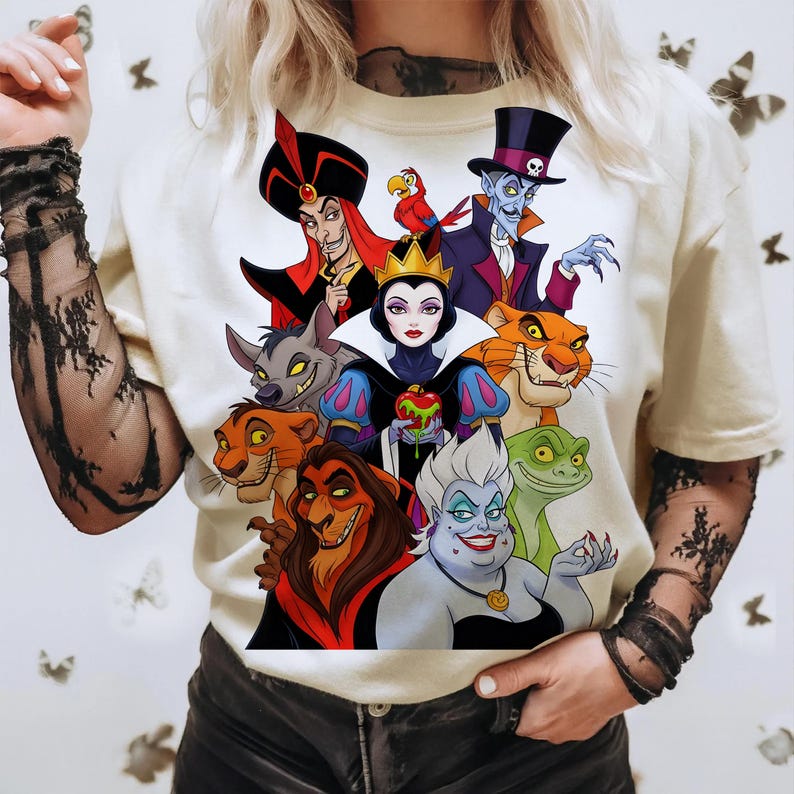 Puede incluir: Camiseta color crema con un gr&aacute;fico colorido de varios villanos de Disney. El dise&ntilde;o incluye personajes como Jafar, la Reina Malvada, Scar y &Uacute;rsula. La obra de arte es vibrante y detallada, mostrando a los villanos ic&oacute;nicos en un estilo de dibujos animados.