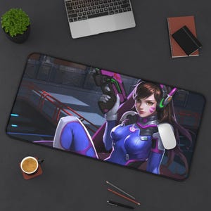 May include: A rectangular desk mat featuring a digital illustration of a character with brown hair wearing a blue and pink suit, holding a futuristic pistol. The character has a headset with green accents and is set against a dark industrial background.