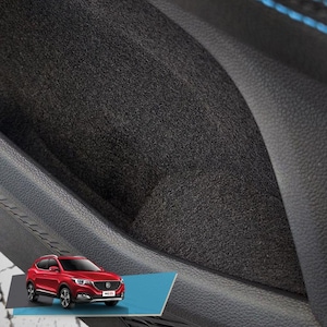 Könnte beinhalten: Nahaufnahme eines schwarzen Autoinnenraums mit einer schwarzen Stoffarmlehne. Die Armlehne hat ein kleines, rechteckiges Ablagefach mit einer schwarzen Stoffauskleidung. Das Fach ist leer.