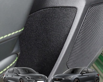 May include: Two grey cars with black accents and black wheels. The cars are parked in front of a black and grey car interior. The interior has a speaker grille and a black fabric panel.