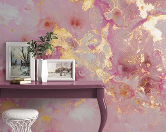 May include: A pink and gold abstract marble wallpaper with a purple table and a white stool in front of it. There are two framed pictures on the table.