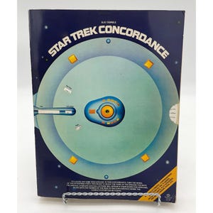 May include: A blue and yellow Star Trek Concordance book cover with a graphic of the Starship Enterprise. The book title is "Star Trek Concordance" and the author is Bjo Trimble.