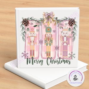May include: A white book with a Christmas-themed design featuring three nutcracker figures in pink, green, and white. The words "Merry Christmas" are written in green script below the figures. The design includes snowflakes and pinecones.