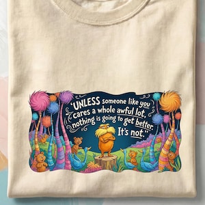 May include: Cream-colored t-shirt featuring a colorful illustration with the text "UNLESS someone like you cares a whole awful lot, nothing is going to get better. It's not." The design includes a character and whimsical trees.