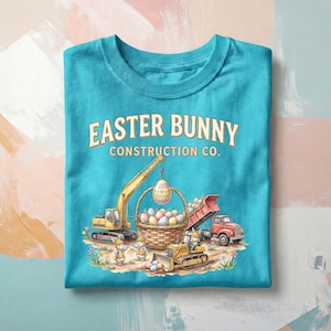 May include: Turquoise t-shirt with the text "EASTER BUNNY CONSTRUCTION CO." and a graphic of construction vehicles, Easter eggs, and bunnies. The design includes a yellow excavator, a red dump truck, and a yellow bulldozer.