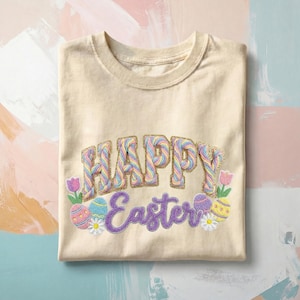 May include: Cream-colored t-shirt with the embroidered text "HAPPY Easter" in pastel colors. The design includes Easter eggs, flowers, and a gold glitter outline, perfect for spring celebrations.