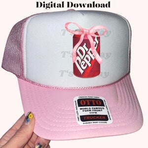 Pu&ograve; includere: Cappellino da camionista rosa con un davanti bianco che presenta una lattina di Dr Pepper con un fiocco rosa. Il cappello ha un'etichetta in bianco e nero che recita "OTTO World Famous Foam Front OSFM Trucker Durable Snap Closure".