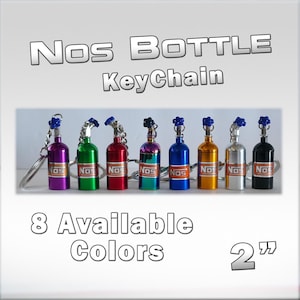 May include: A collection of eight colorful NOS bottle keychains, each approximately 2 inches tall. The keychains feature a small bottle design with a blue top and the word "NOS" printed on the bottle. Available in various colors.