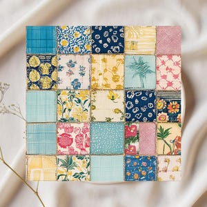 May include: A square patchwork textile with a variety of patterned fabric squares in shades of blue, yellow, pink, and green. The fabrics feature floral and geometric designs. The piece is likely a decorative item or part of a larger textile project.