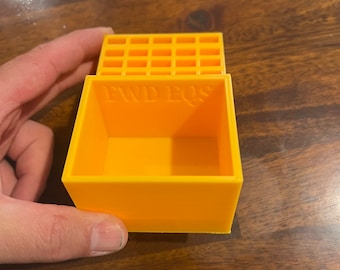 Peut inclure: Une boîte en plastique jaune avec un dessus quadrillé et les mots "FWD EOS" imprimés sur le devant.