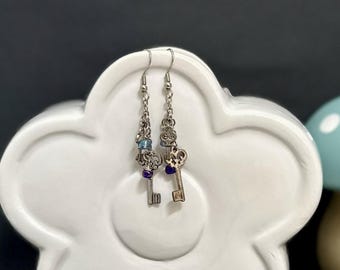 Key charm earrings featuring light blue and purple accent beads