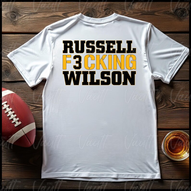 May include: White t-shirt with black and yellow text that reads "Russell F3cking Wilson".