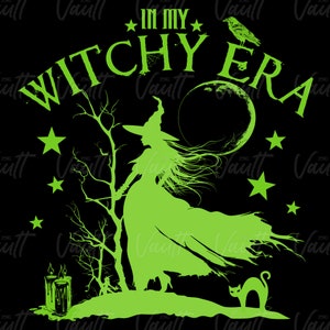 May include: A black graphic featuring a green witch silhouette with long hair, a hat, and a flowing dress. The text "IN MY WITCHY ERA" arches above the witch. Stars, a raven, a cat, and a moon complete the design.