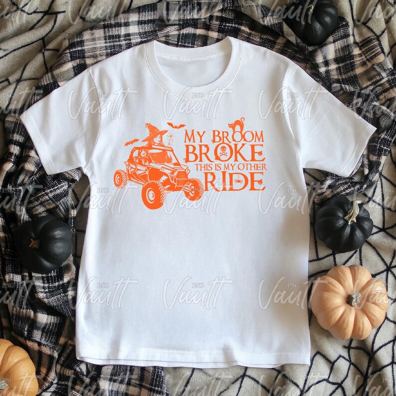 May include: White t-shirt with an orange graphic of a Halloween-themed off-road vehicle. The text reads "My broom broke, this is my other ride."