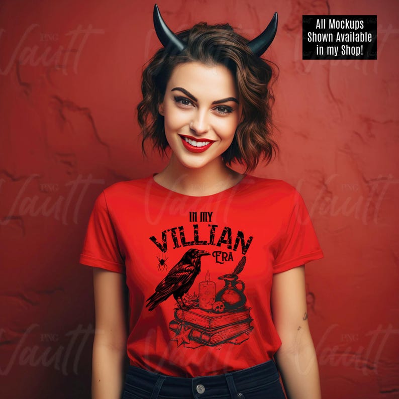 Puede incluir: Una camiseta roja con un dise&ntilde;o gr&aacute;fico negro que presenta un cuervo, una vela, una botella de poci&oacute;n y libros. El texto "In My Villian Era" est&aacute; impreso en la camiseta.