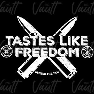May include: White graphic design on a black background with two crossed bullet casings. The text reads "Tastes Like Freedom" with a circle logo on each side that says "Shield Republic" and the text "Defend the 2nd" at the bottom.