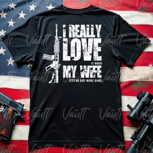 Peut inclure: T-shirt noir avec texte blanc et un dessin de fusil. Le texte dit "I REALLY LOVE IT WHEN MY WIFE LETS ME BUY MORE GUNS."