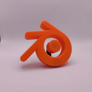 Puede incluir: Un logotipo naranja impreso en 3D del motor de juego Unity. El logotipo es una letra estilizada "G" con un círculo en su interior.