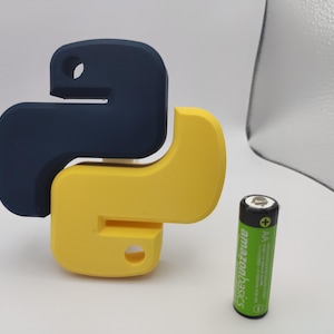 K&ouml;nnte beinhalten: Ein 3D-gedrucktes Python-Logo in Blau und Gelb. Das Logo ist schlangenf&ouml;rmig und etwa so gro&szlig; wie eine AA-Batterie.