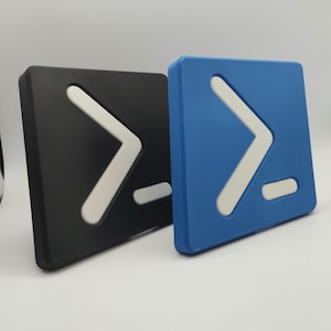 Könnte beinhalten: Zwei quadratische Objekte, eines schwarz und eines blau, jeweils mit einem weißen, stilisierten Pfeil nach rechts und einem kleinen horizontalen Strich. Diese 3D-gedruckten Artikel sind wahrscheinlich dekorativ oder funktional.