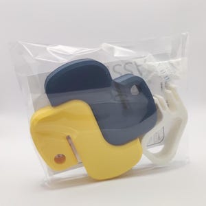 K&ouml;nnte beinhalten: Ein gelber und blauer Python-Logo-Schl&uuml;sselanh&auml;nger aus Kunststoff. Der Schl&uuml;sselanh&auml;nger befindet sich in einer durchsichtigen Plastikt&uuml;te.
