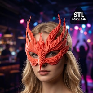 May include: A vibrant red mask with intricate feather-like details, covering the eyes and nose. The mask is worn by a person with blonde hair. The image includes the text "STL DOWNLOAD" in a black triangle. The background is a blurred party scene.