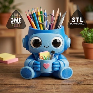 May include: A blue robot desk tidy holding stationery items like pencils and scissors. The robot has large eyes and a smiling face. A small cup in its hands holds paperclips and a pink heart. The text "3MF PAINTED" and "STL DOWNLOAD" are visible.