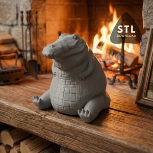May include: A gray alligator figurine with a textured, scaly body sits on a wooden surface. The alligator is in a seated position with its legs extended. The background features a fireplace with a burning fire and the text "STL DOWNLOAD".