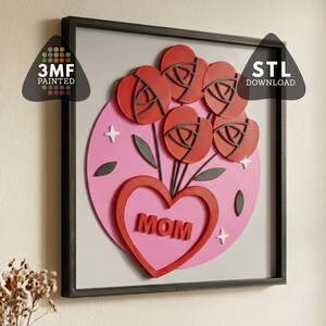 以下が含まれることがあります： 赤いバラの花束、"MOM"の文字が入ったハート、"STL DOWNLOAD"が描かれた額入りのアートワーク。デザインはピンク色の背景にあり、グレーのフレームで囲まれています。"3MF PAINTED"の文字も表示されています。装飾品。