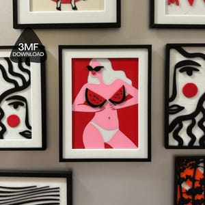 Pode incluir: Uma peça de arte de parede emoldurada com uma figura estilizada de cabelo branco e óculos de sol pretos, vestindo uma parte de baixo de biquíni branca e segurando duas fatias de melancia sobre o peito. Fundo de cor vermelha vibrante.