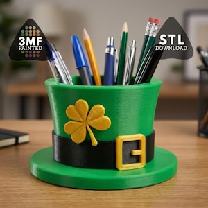 May include: A green leprechaun hat-shaped desk organizer with a gold shamrock and buckle. The hat holds pens and pencils. The text "3MF PAINTED" and "STL DOWNLOAD" are visible.