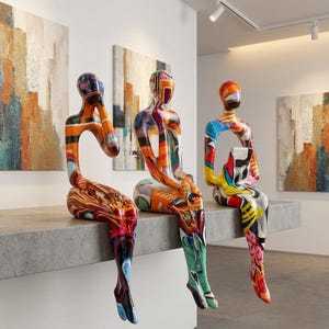 Può includere: Tre sculture astratte a forma umana sedute su una sporgenza. Ogni figura presenta una finitura lucida e multicolore con motivi vivaci in arancione, blu, giallo, rosso e nero. Le sculture sono in posizione seduta con le gambe a penzoloni.