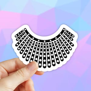 May include: Black and white sticker of a RBG collar, a symbol of the late Supreme Court Justice Ruth Bader Ginsburg.