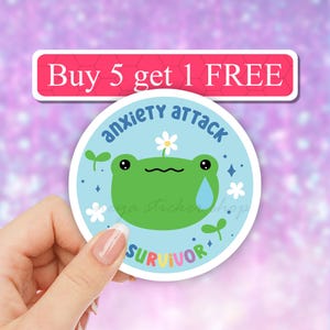 May include: A round sticker with a blue background and a green frog with a flower on its head. The frog is crying a blue tear. The text on the sticker says "anxiety attack survivor" in rainbow letters.