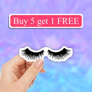 May include: A black and white sticker featuring a pair of stylized eyelashes. Above the sticker, a rectangular pink banner with a honeycomb pattern displays the white text "Buy 5 get 1 FREE" in a clear, serif font against a blurred background.