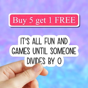 May include: White sticker with black text that reads "It's all fun and games until someone divides by 0". A hand is holding the sticker. Above the sticker is a pink banner with white text that reads "Buy 5 get 1 FREE".