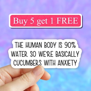 May include: White sticker with black text that reads "Buy 5 get 1 FREE" and "THE HUMAN BODY IS 90% WATER SO WE'RE BASICALLY CUCUMBERS WITH ANXIETY".