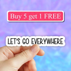 May include: White sticker with the text "LET'S GO EVERYWHERE" in black lettering. A separate white sticker with a pink honeycomb pattern and the text "Buy 5 get 1 FREE" in white lettering is visible in the background.