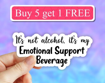 May include: White sticker with black text that reads "It's not alcohol, it's my Emotional Support Beverage". A hand is holding the sticker. A pink and purple background with the text "Buy 5 get 1 FREE" in a white rectangle.