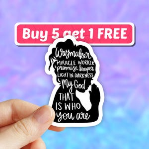 May include: Black and white sticker with a silhouette of a woman praying with the text "Waymaker, Miracle Worker, Promise Keeper, Light in Darkness, My God That Is Who You Are."