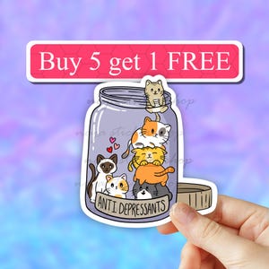May include: A sticker of a glass jar filled with a stack of cute cartoon cats. The jar has the text "Anti Depressants" on the front. The sticker has a pink banner at the top that says "Buy 5 get 1 FREE".
