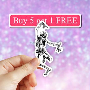 May include: A black and white sticker of a skeleton dancing with the text "Buy 5 get 1 FREE" on a pink background.