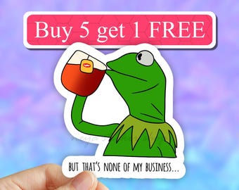 May include: A green frog meme sticker with the text "Buy 5 get 1 FREE" at the top and "But that's none of my business..." at the bottom. The frog is holding a cup of tea.