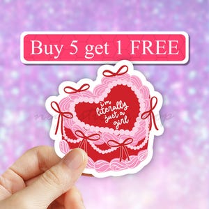 May include: Pink and red heart-shaped cake sticker with the text "I'm literally just a girl".