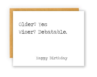 May include: A white card with black text that reads "Older? Yes Wiser? Debatable. Happy Birthday".