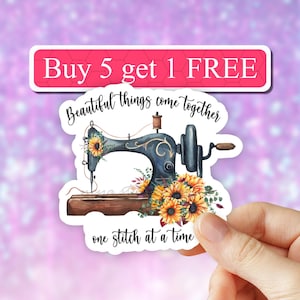 May include: A white sticker with a blue sewing machine and sunflowers. The text on the sticker reads "Buy 5 get 1 FREE Beautiful things come together one stitch at a time."