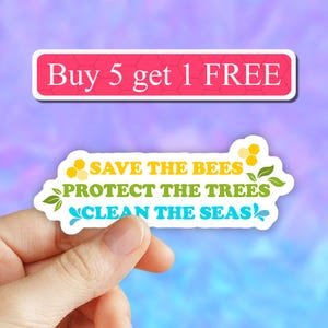 May include: White sticker with the text "Save the Bees, Protect the Trees, Clean the Seas" in yellow, green, and blue lettering. The sticker also has a small honeycomb design in yellow and a small leaf design in green. The sticker is held in a hand. A pink banner above the sticker reads "Buy 5 get 1 FREE".